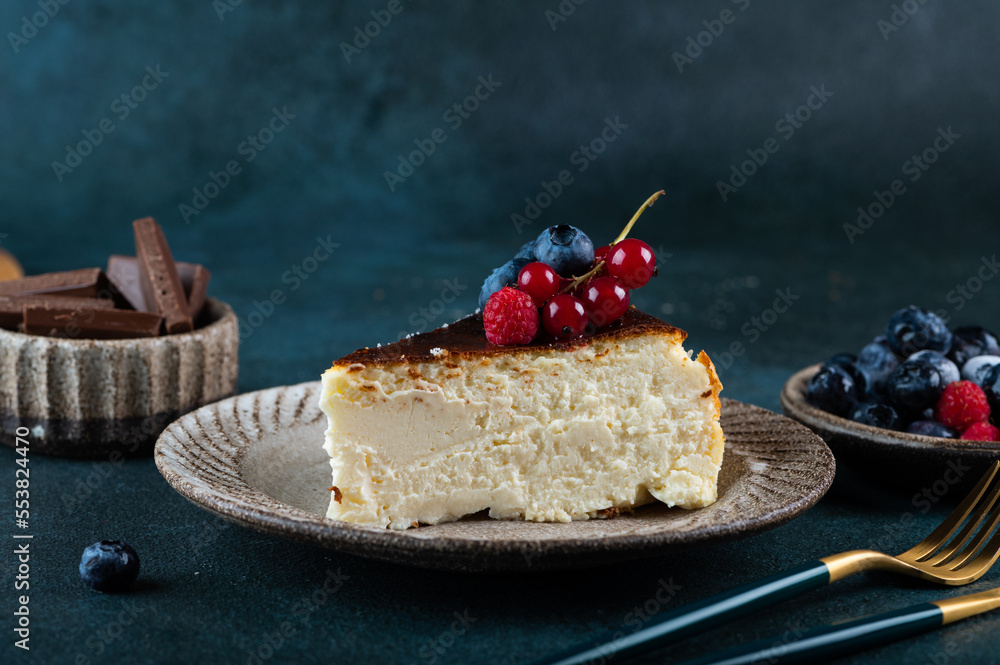 Obraz premium Piece of San Sebastian Basque Cheesecake with berries. Basque cheesecake. Popular dessert. Burnt cheesecake.