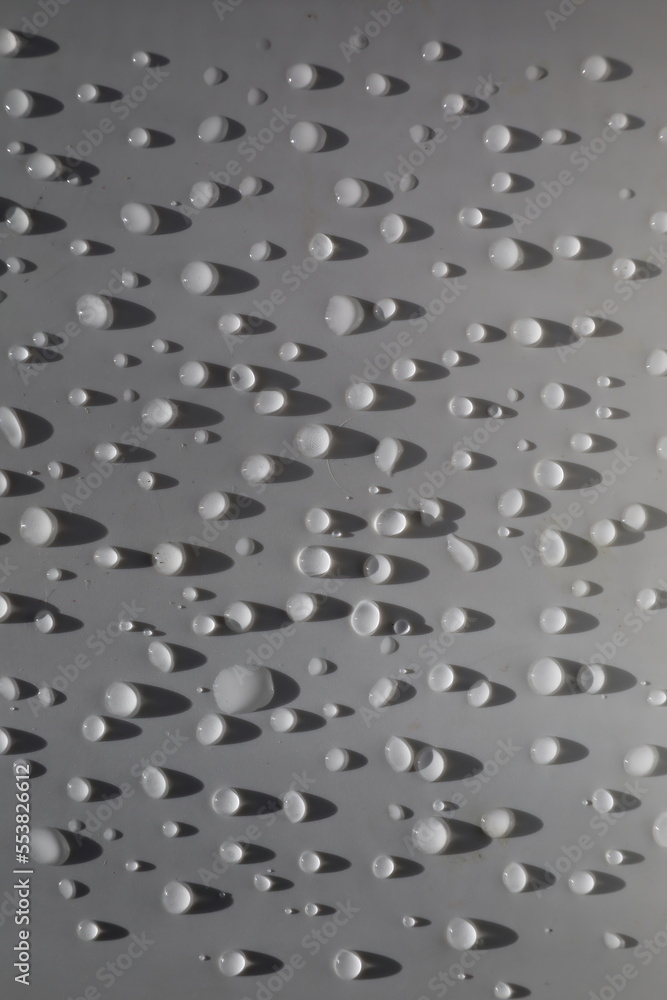 Fototapeta premium Drops on the white surface in close up 