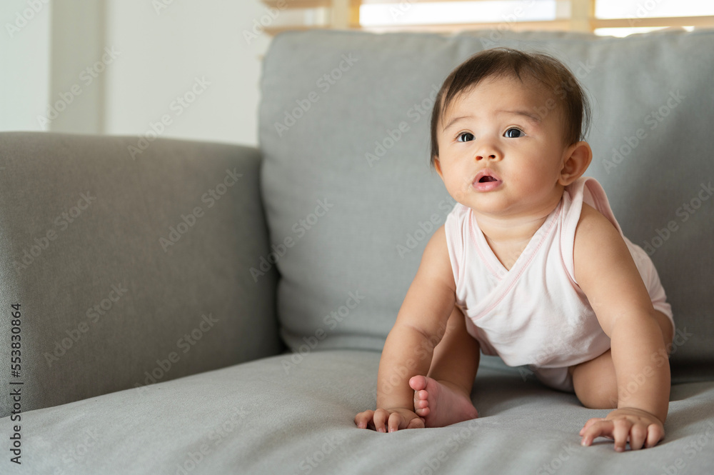 Portrait of baby girl sitting on sofa at home, family, child, childhood and parenthood concept Portrait of baby girl sitting on sofa at home, family, child, childhood and parenthood concept