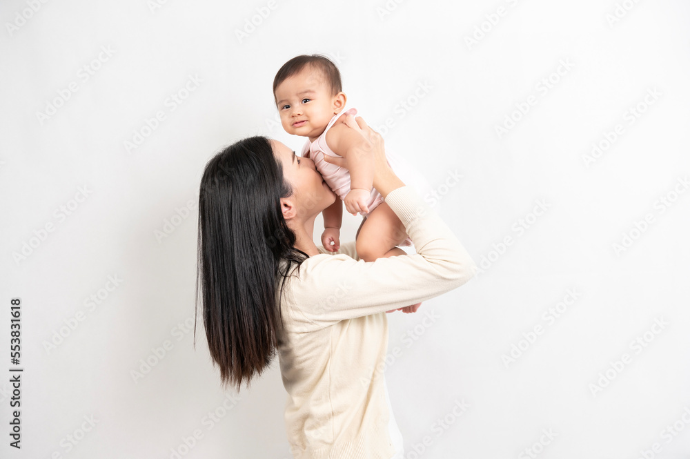 Beautiful mother and adorable baby girl are happy on white background, family, child, childhood and parenthood concept Beautiful mother and adorable baby girl are happy on white background, family, child, childhood and parenthood concept