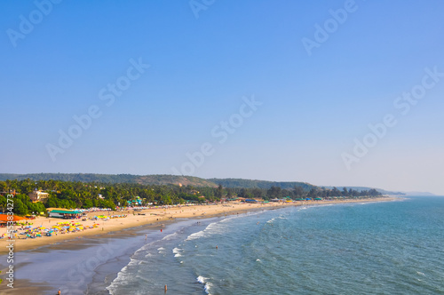 View from a distance on the beach with tourists in Arambol, Goa, India