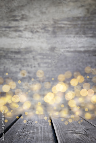 Empty grey rustic wooden table with blurred Christmas lights. Wood surface and defocused bokeh gold lights at background. New year mood.