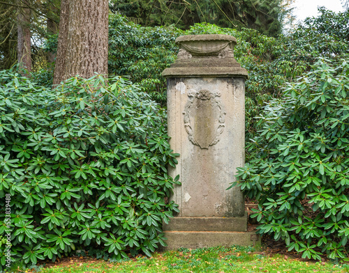 Alter Grabstein mit einer Pflanzschale und schönen Ornamenten auf einem Friedhof in Hamburg