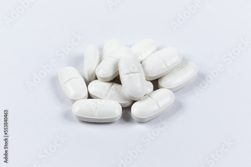 many white oval medical tablets for humans and animals, medicinal antibiotics pills medicine closeup