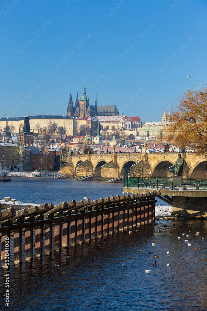 Fototapeta premium Snowy Prague Lesser Town with Prague Castle above River Vltava in the sunny Day , Czech republic