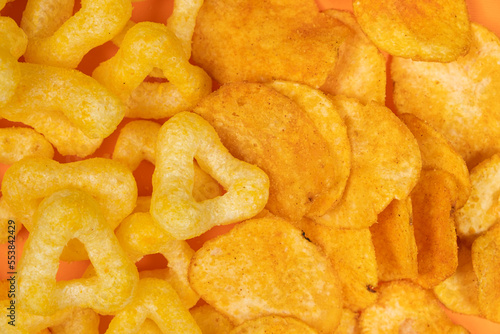 Crispy potato and corn chips, close-up view from above.