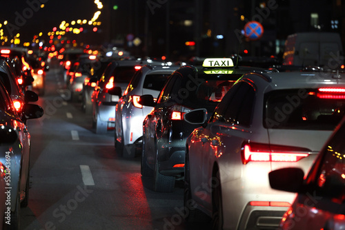 Samochody stoją w mieście w czasie wieczornego szczytu w korku przed świętami zimowymi.