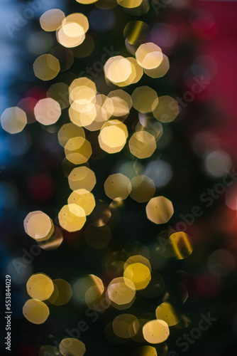 A beautiful blurred Christmas tree in the bokeh style, a house with a green Christmas tree, gifts, garlands, candles, decorated interior. New Year's background. Christmas background.