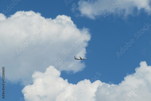 Airplane in blue sky on clouds background