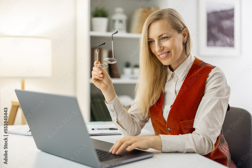 Beautiful smiling lady freelancer working at home, having an oline conversation with customers Beautiful smiling lady freelancer working at home, having an oline conversation with customers