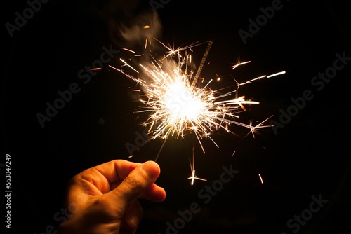Human hand holding a burning sparkler. Bengal fire