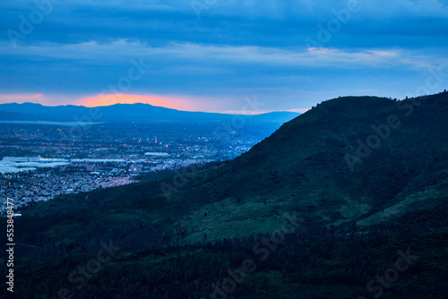 green mountain in blue hour with cloudy sky, city in the background with little sunset, sierra de guadalupe with coacalco in the background in state of mexico 