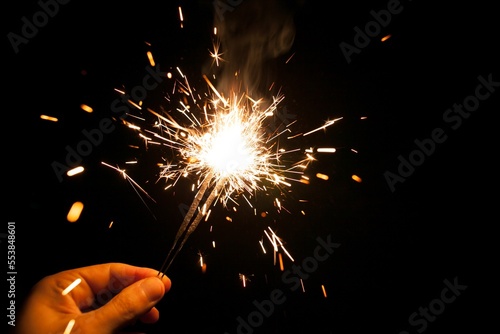 Human hand holding a burning sparkler. Bengal fire
