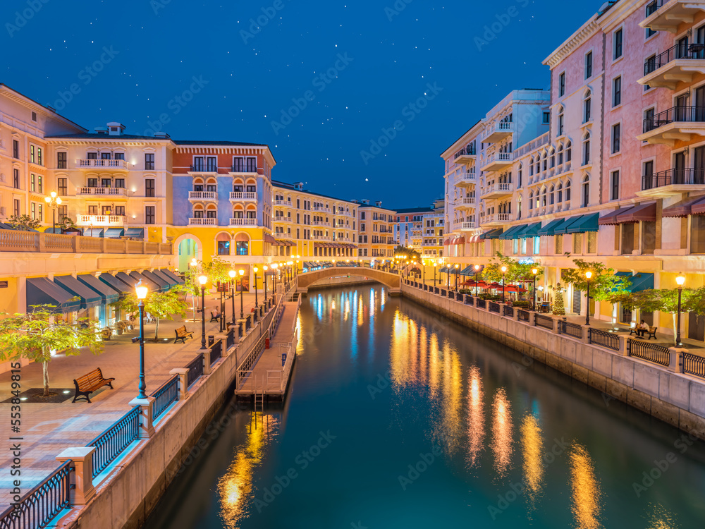 Long exposure shot of Qanat Quartier suburb's canal side colorful buildings in Doha, Qatar