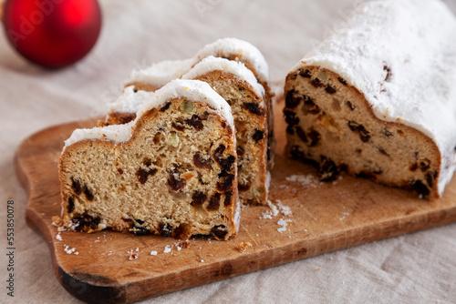 Homemade Christmas Stollen Bread on a rustic wooden board, side view.