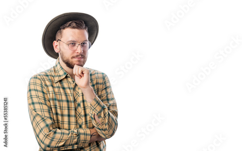 Portrait of handsome young male in cowboy hat and shirt standing on white background