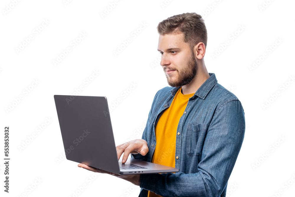 Young caucasian male in yellow in casual clothing holding laptop on white background, studio shot Young caucasian male in yellow in casual clothing holding laptop on white background, studio shot