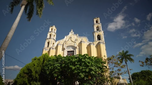 Slow trucking view to the left of Cathedral of San Juan in Merida, Yucatan Mexico with a clear blue sky on sunny day. photo