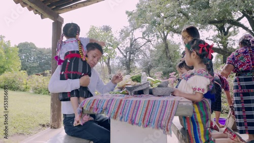 Familia Latina cocinando en el jardin de su casa. Padre jugando con su pequeña niña.  photo