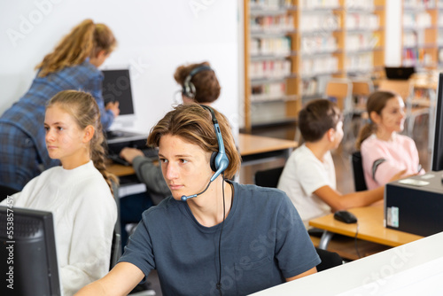 Schoolboy and schoolgirl working with computers in classroom
