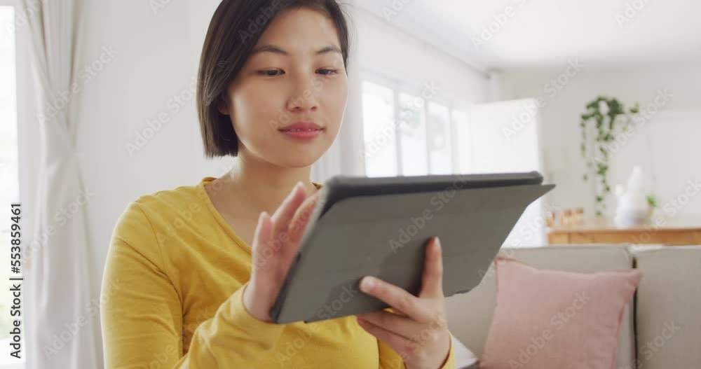Portrait of happy asian woman using tablet in living room Portrait of happy asian woman using tablet in living room