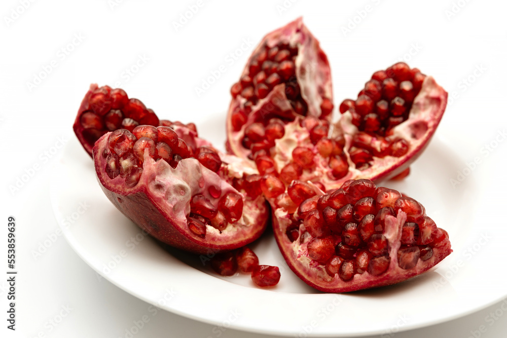 Peeled pomegranate on a white background in a plate Peeled pomegranate on a white background in a plate