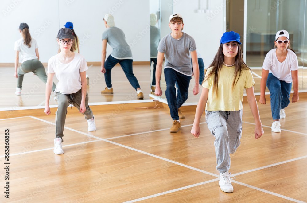 Positive teenage girls and boys training hip hop in dance studio, dance classes for teens