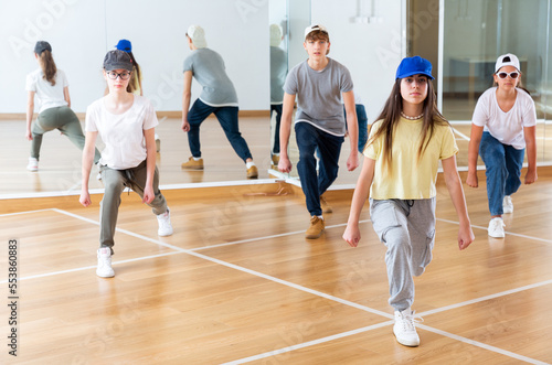 Positive teenage girls and boys training hip hop in dance studio, dance classes for teens © JackF