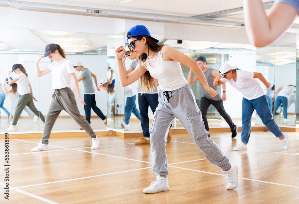 Teenage dance group teaches hip-hop dance in dance studio