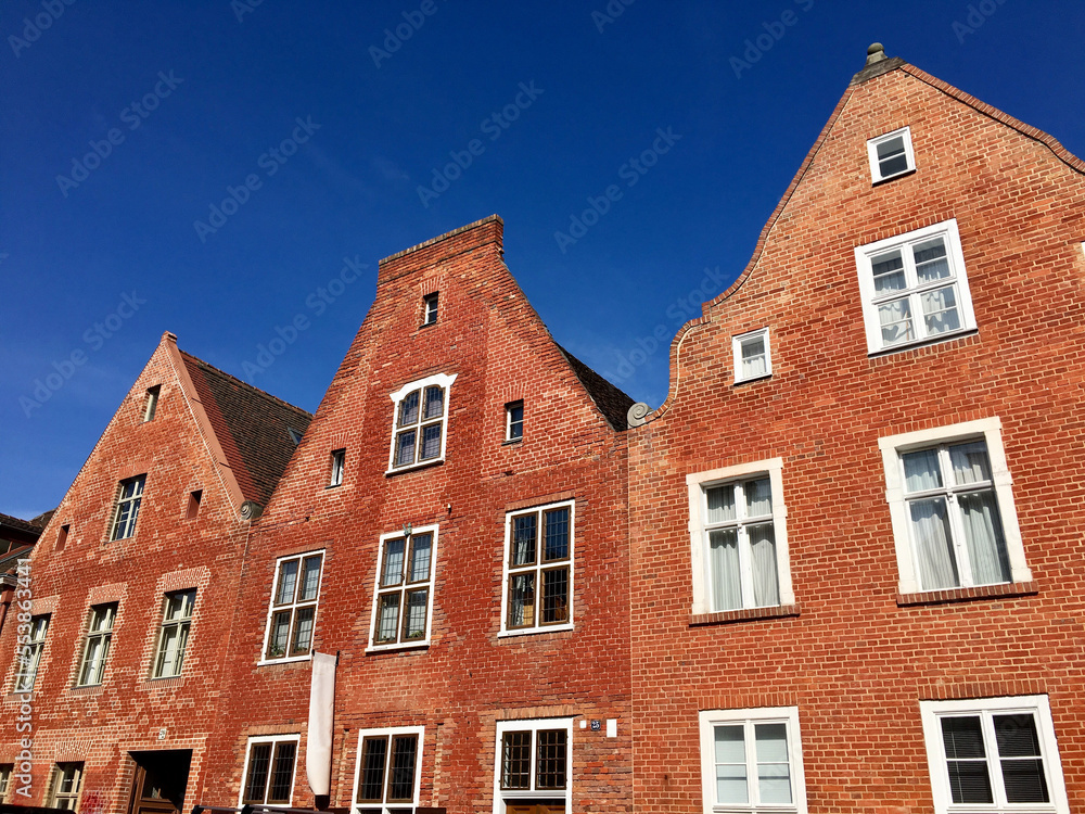 Red brick building with big windows and blue sky above.