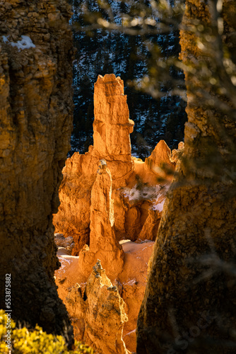 close up telephoto zoom photo of bryce canyon national park hoodoos lit by sun illuminating reds, oranges, pinks, and whites.