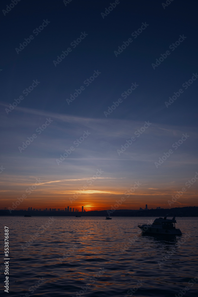 Dark blue and warm orange colored sky, sunset at istanbul, Turkey (Constantinople) with fisher boats and cityview, landscape