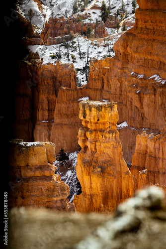 close up telephoto zoom photo of bryce canyon national park hoodoos lit by sun illuminating reds, oranges, pinks, and whites.
