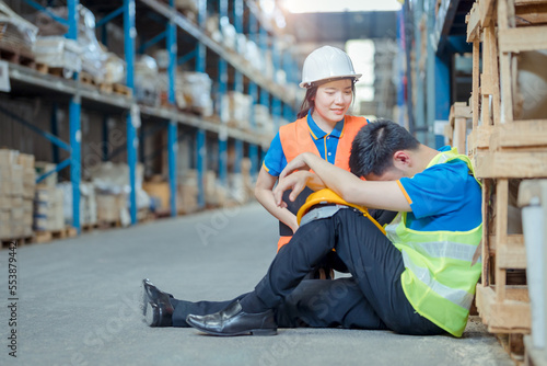 Tired warehouse worker staff sitting on floor in warehouse. This is a freight transportation and distribution warehouse. Industrial and industrial workers concept