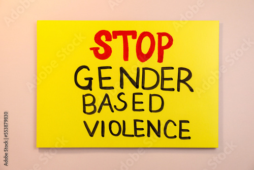 Yellow card with text Stop Gender Based Violence on pink background, top view