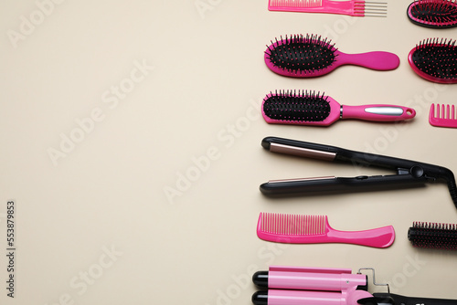 Fototapeta Naklejka Na Ścianę i Meble -  Flat lay composition of professional hairdresser tools on beige table, space for text