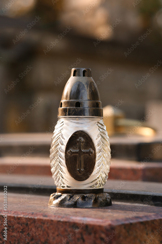 Grave lantern on granite surface in cemetery