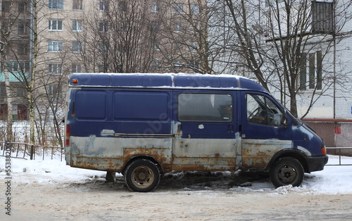 Old rusty blue minivan parked on the road, Iskrovsky Prospekt, St. Petersburg, Russia, december 2022
