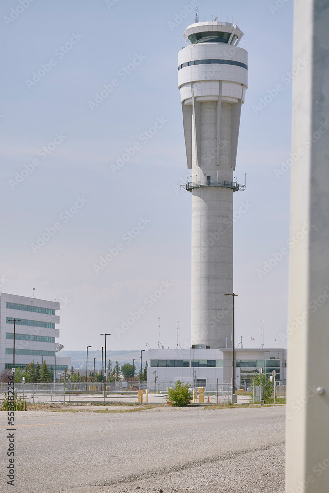 White control tower with small buildings surrounding the parking building