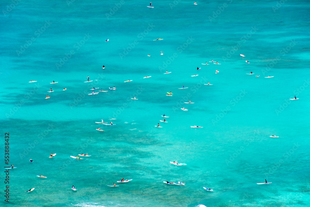 Surfers catching and riding waves in the beautiful turquoise waters of Waikiki Beach on Oahu, Hawaii. Surfers catching and riding waves in the beautiful turquoise waters of Waikiki Beach on Oahu, Hawaii.