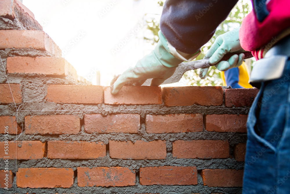 Fototapeta premium Close up of bricklayer building walls