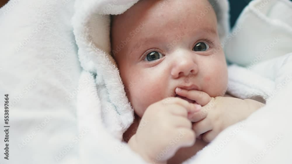 infant girl a newborn sucking thumb. happy family kid dream concept. close up cute newborn baby lifestyle wrapped in bath towel at home indoors. daughter a small child sucks his thumb after bathing infant girl a newborn sucking thumb. happy family kid dream concept. close up cute newborn baby lifestyle wrapped in bath towel at home indoors. daughter a small child sucks his thumb after bathing