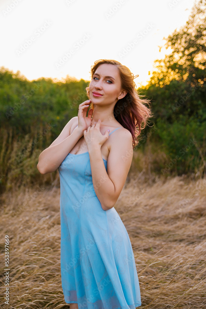 A young woman walks in a clearing. A walk in the park or forest. Outdoor recreation. The atmosphere of freedom and nature. A young woman walks in a clearing. A walk in the park or forest. Outdoor recreation. The atmosphere of freedom and nature.
