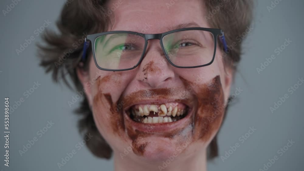 Dental care. Healthy and eating. Large amounts of sweets are harmful to dental health and cause diabetes. Adult woman dirty face of chocolate with broken in half tooth with sticking out fiber pin. Dental care. Healthy and eating. Large amounts of sweets are harmful to dental health and cause diabetes. Adult woman dirty face of chocolate with broken in half tooth with sticking out fiber pin.