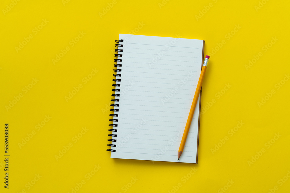Blank notebook and a pen on yellow background Blank notebook and a pen on yellow background