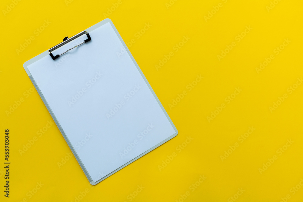 Clipboard with a paper on yellow background Clipboard with a paper on yellow background