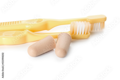 Toothbrushes and ear plugs on white background