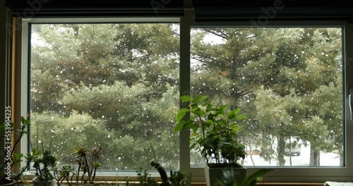 A lot of snow is falling through the window
