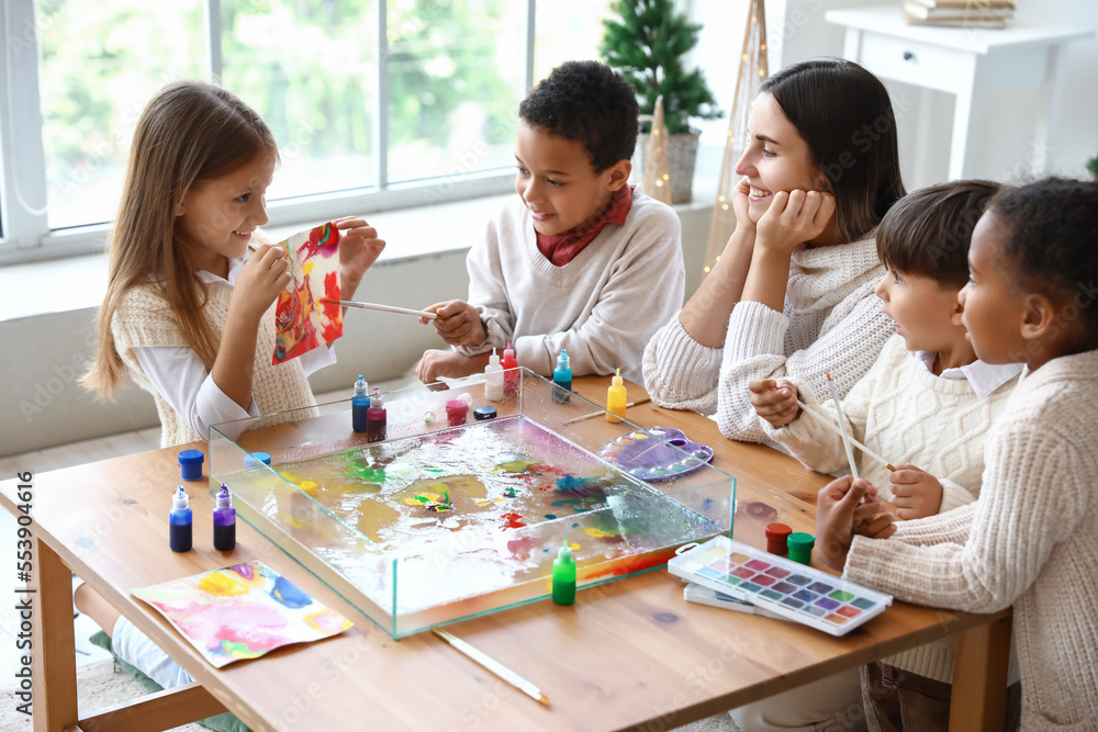 Little children with teacher during master class in Ebru painting on Christmas eve Little children with teacher during master class in Ebru painting on Christmas eve