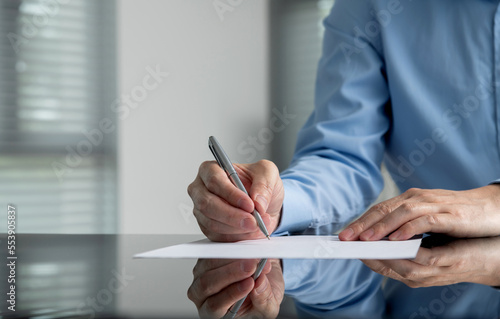Fotografie Businessman hand writing on paper